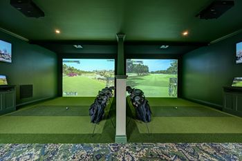 A room with green walls and a large screen showing a golf course.